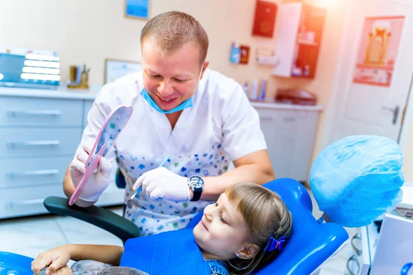 可爱的女孩在牙科诊所。与牙医一起在口腔科的儿童。儿科口腔学概念. — 图库照片