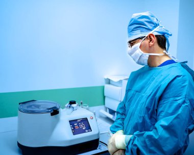 Doktor klinikte elektronik kan santrifüjüyle çalışıyor. Scrabs 'da laboratuvar asistanı. Tıbbi odada mavi ışık.
