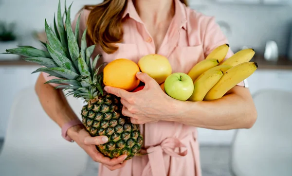 Chica sana con frutas en el fondo de la cocina moderna. Comida saludable y concepto de dieta. Foto recortada —  Fotos de Stock