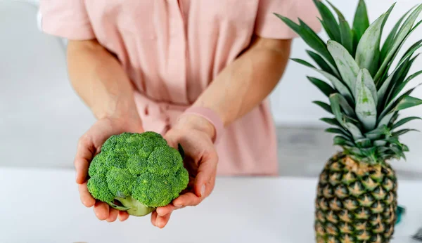 Kuchyně a zelenina. Dívka drží brokolici v rukou. Dietní dieta — Stock fotografie