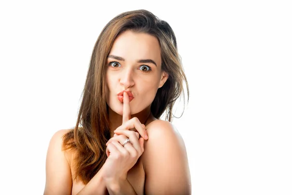 Jeune femme tenant un doigt sur ses lèvres, geste silencieux. Gros plan d'une jeune femme qui dit "shh", demandant de garder le silence sur le secret. Concept d'émotion — Photo