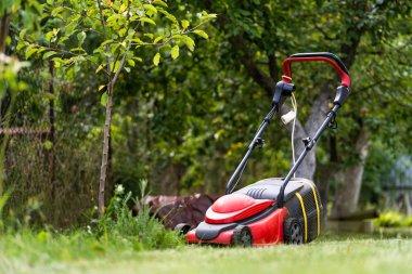 Yeşil çimlerin üzerindeki çim biçme makinesi. Bahçe manzarası. Manzara ve arazi için özel ekipman. Bahçe işleri konsepti. Yakın çekim..