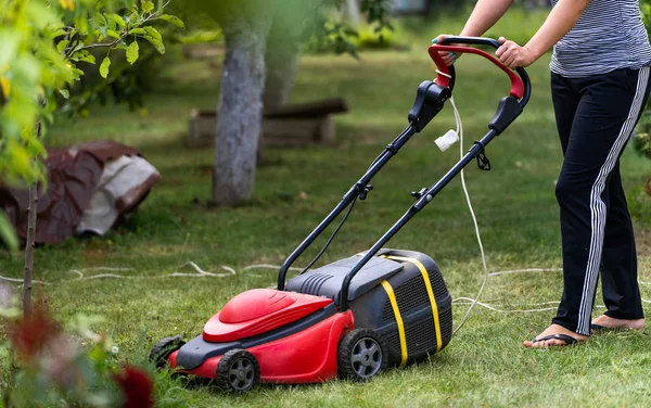 Gardener mowing the lawn at backyard. Landscape, terrain at backyard. Special equipment for landscape, terrain. Gardening concept. Closeup. — Stock Photo, Image
