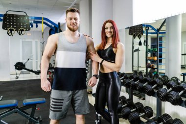 Fitness stüdyosunda duran fit bir çiftin portresi. Sağlıklı yaşam sporu kavramı.