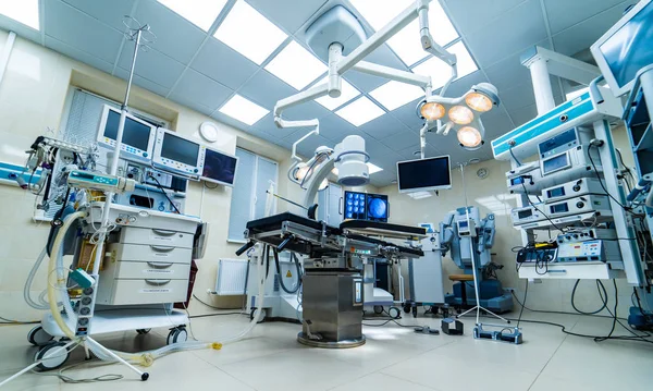 Interno ospedaliero con tavolo operatorio, lampade e dispositivi ultramoderni, tecnologia in clinica moderna — Foto Stock