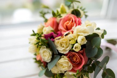 Güzel, yumuşak bir buket krema, pembe güller ve bulanık arka planda Eustoma çiçekleri. Düğün detayları konsepti.