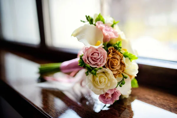Gyönyörű, puha esküvői csokor krém, elefántcsont és rózsaszín rózsával az ablakpárkányon. Közelkép — Stock Fotó