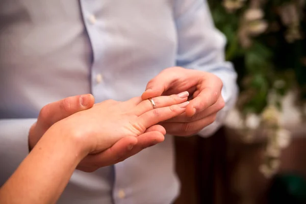 Un uomo che indossa una fede sulla mano di una donna. Sposo e sposa concetto. Concentrazione selettiva. Primo piano — Foto Stock