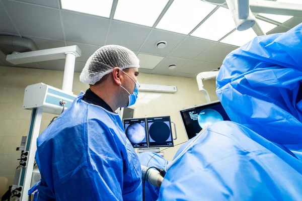 Equipo médico realizando operación quirúrgica en sala de cirugía moderna y luminosa. Teatro de operaciones. Equipo moderno en la clínica. Sala de emergencias. — Foto de Stock