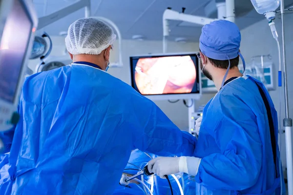 Equipo de cirujanos realizando la operación en la sala de cirugía moderna y luminosa. Teatro de operaciones. Equipo moderno en la clínica. Sala de emergencias . — Foto de Stock