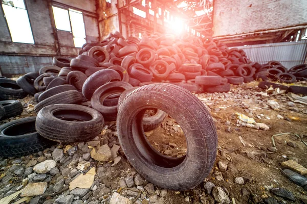 Un mucchio di vecchie gomme marce sul retro dell'edificio in rovina — Foto Stock