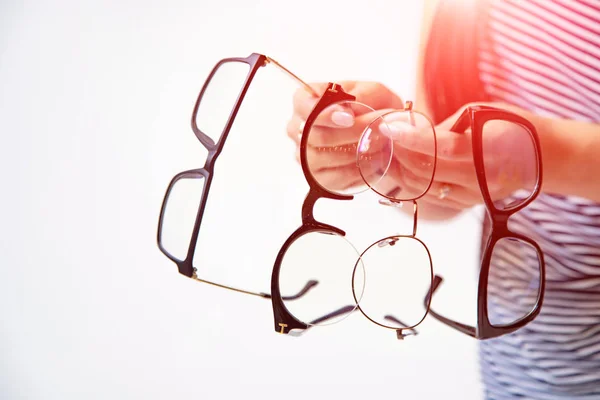 Woman's hands holding few pairs of glasses isolated on white. Sp — 스톡 사진