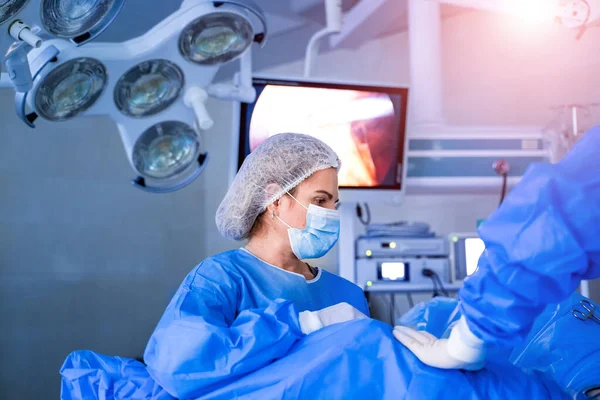 Equipo médico realizando operación quirúrgica en quirófano moderno — Foto de Stock