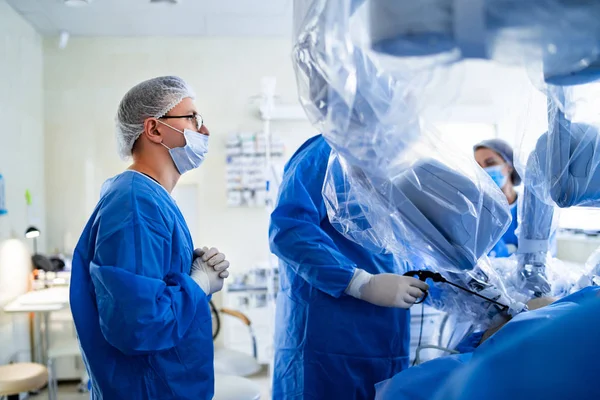 Cirugía espinal. Grupo de cirujanos en sala de operaciones con equipo quirúrgico. Doctor en la pantalla. Anteojos médicos modernos. Cirugía espinal. —  Fotos de Stock