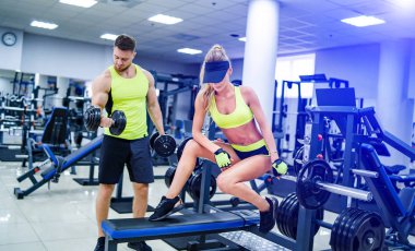 Trainer and client at the gym with sport equipment. Young and fit. Healthy fitness life concept. Nice body and long legs, healthy lifestyle.