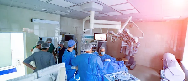 Egy műtéti csapat, akik egy beteget operálnak egy műtőben. Panorámás kilátás — Stock Fotó