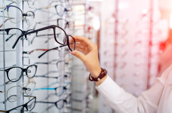 Raw of glasses in background in optical shop. Spectacles in woma