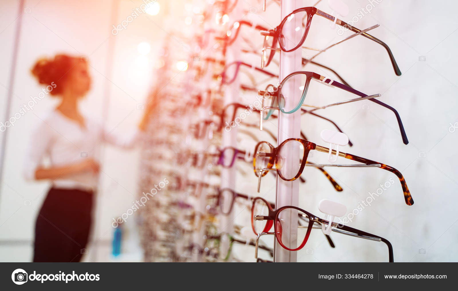 Fila de gafas en una optica. Tienda de anteojos. Soporte con gafas en la tienda de optica. La mujer elige los anteojos. Correccion de la vista. Foto de stock 334464278 wedmov