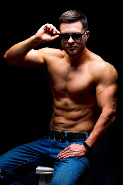 Portrait of a athletic muscular bearded man posing on a black background. — Stock Photo, Image