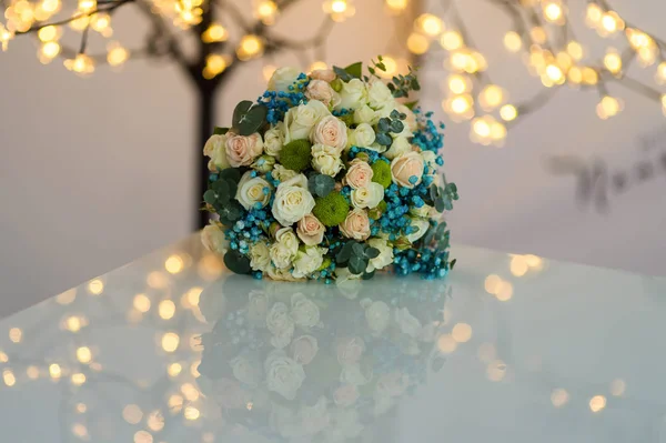Beautiful and colourful bouquet of flowers over white table with blurred lights background — Stock Photo, Image