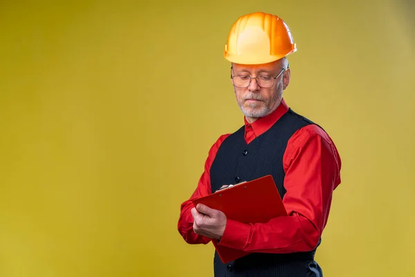 Serious general contractor or real estate investor concept with elegant man with beard, glasses and building helmet. Man in elegant shirt. Copy space.