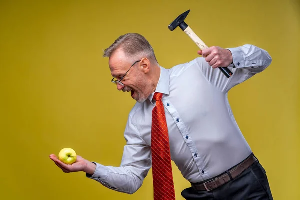 Сильний Бізнесмен Сорочці Тримає Молоток Вказуючи Яблуко Ізольовано Жовтому Тлі — стокове фото
