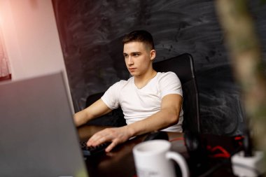 Ofiste çalışan yakışıklı genç bir programcı. Programlama ve kodlama teknolojileri geliştiriliyor.