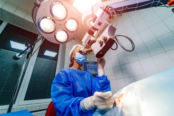 Ung Kvinna Med Respirator Läkare Inför Operationen Och Titta Mikroskop — Stockfoto