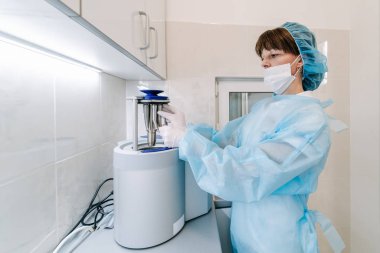 Otoklavda tıbbi aletler sterilize ediliyor. Diş hekimliği. Dişçi asistanı otoklavdan tıbbi aletleri sterilize ediyor. Seçici odaklanma. Steril diş aletleri