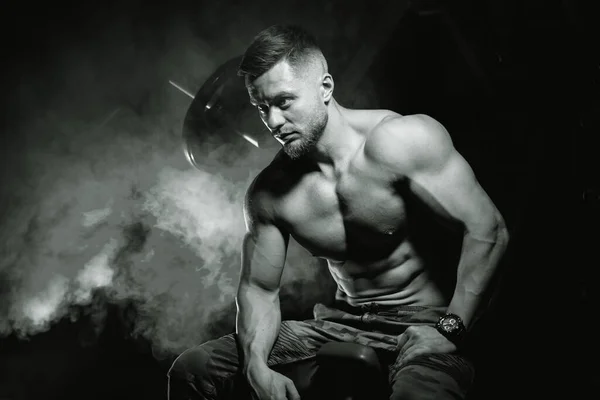 Bodybuilder Poseren Zwarte Achtergrond Zittend Bank Training Een Gespierde Man — Stockfoto