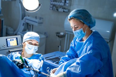 Travma cerrahisi işlemi. Ameliyathanede ameliyat ekipmanlarıyla bir grup cerrah. Tıbbi geçmiş, seçici odak