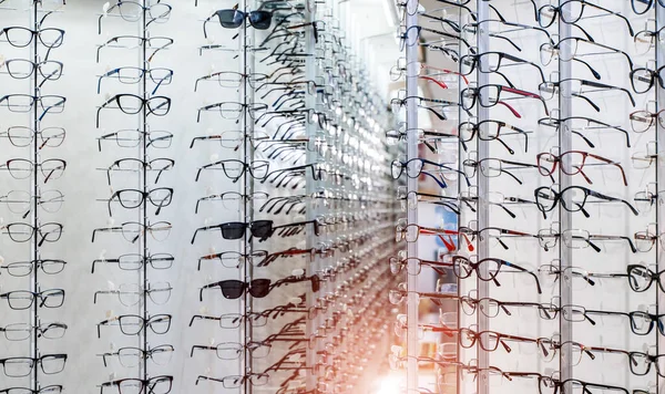 Vetrina con occhiali nel moderno negozio oftalmico. Primo piano . — Foto Stock