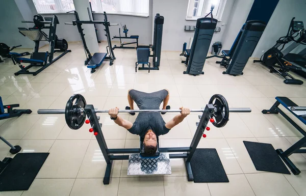 Bodybuilder-Trainer beim Bankdrücken im Fitnessstudio. Foto von oben. Starke Bauchmuskeln. Gesundheitssport-Konzept. — Stockfoto