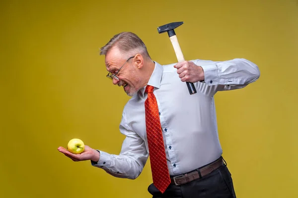 Сильний Бізнесмен Сорочці Чоловік Тримає Молоток Вказуючи Яблуко Ізольовані Жовтому — стокове фото