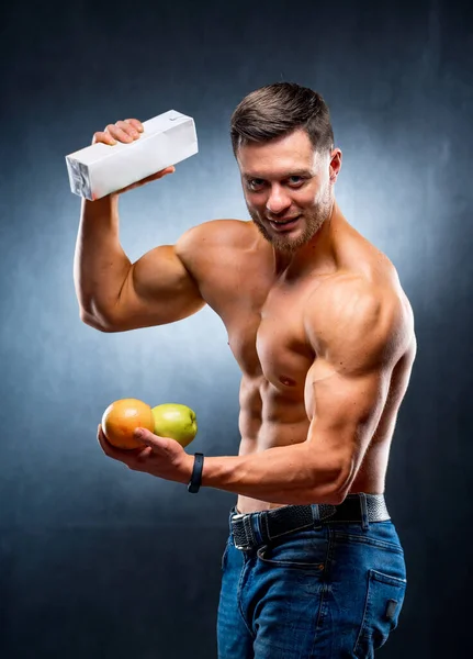 黒の背景に裸の胴を持つ男運動選手 ボディビルダーは果物やジュースを保持します ライフスタイルコンセプト — ストック写真
