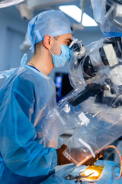 전문가들이 장비를 사용하여 수술을 마스크를 외과의가 수술실에서 현미경을 들여다보는 — 스톡 사진
