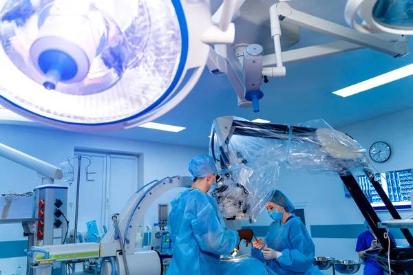 Team surgeon at work in operating room. Modern equipment in clinic. Operating room with X-ray medical scan