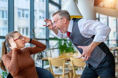 Öfkeli iş adamı, modern ofisteki hayal kırıklığına uğramış bir kız üzerinde çalışmaktan memnun olmadığını ifade ediyor..