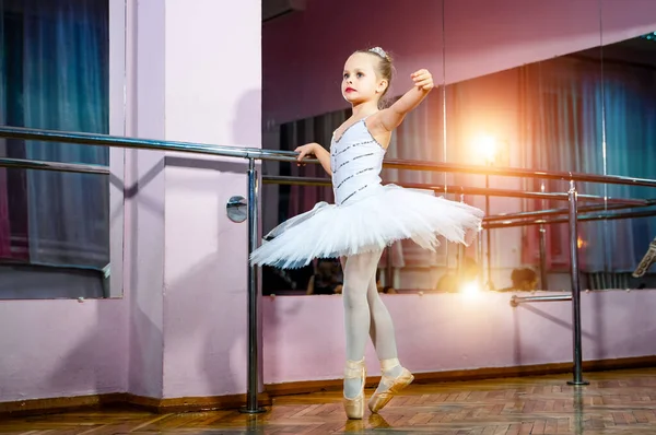 小芭蕾舞演员在白色 Tutu 站在旁边的镜子与她的倒影在舞蹈工作室 儿童和芭蕾概念 — 图库照片