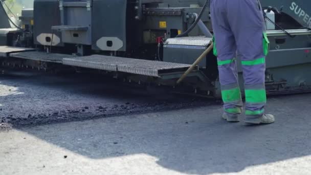 Arbeiter Legen Vor Dem Hintergrund Der Fertigungsmaschine Asphalt Auf Die — Stockvideo