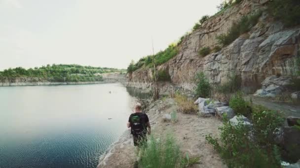 Turysta Plecakiem Idzie Wzdłuż Brzegu Rzeki Tle Skał Dzikiej Przyrody — Wideo stockowe
