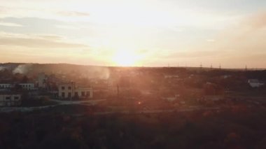 Sıcak bir yaz akşamında gün batımında çıkan kuraklıktan çıkan yangın sonrası dumanla kaplanan banliyö altyapısının manzarası. Hava görünümü