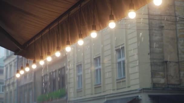 Вид Ряд Горящих Лампочек Крыши Ресторана Фоне Дождевых Капель Улицы — стоковое видео