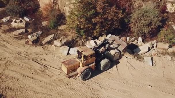 带有铲斗的专业推土机正在采石场背景下的石头附近撒沙 后续行动 — 图库视频影像