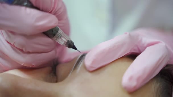 Esteticista Luvas Está Desenhando Forma Das Sobrancelhas Com Uma Agulha — Vídeo de Stock