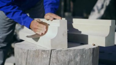 Usta, öğleden sonra sokağın ortasında bir kütüğün üzerinde zümrüt bir bezle ahşap bir ürünü cilalıyor..