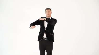 Siyah takım elbiseli ve beyaz gömlekli komik adam beyaz stüdyonun arka planında makarena yapıyor. Popüler dansın parodisi. Macarena