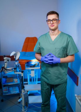 Hasta muayenesinden önce jinekolog klinikte jinekoloji kürsüsünün yanında duruyor..