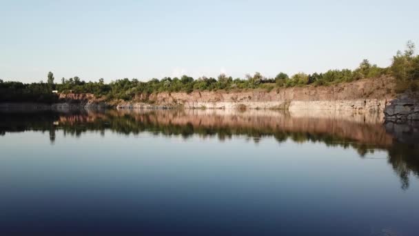 Vue aérienne d'un beau lac sur le site d'une ancienne carrière. Beaux paysages de nature sauvage avec un lac avec de hautes rives de pierre. Vidéo 4k .