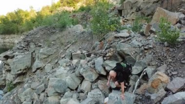 Dev bir kayalık dağ boyunca yürüyen genç bir adamın hava manzarası. Uçurumdaki gezgin. Seyahat kavramı.